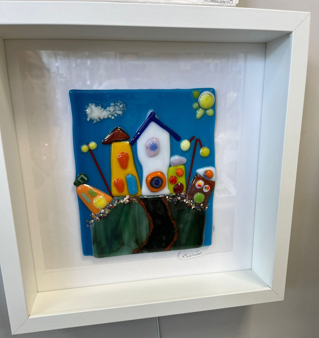 Fused glass piece, framed in white box frame.